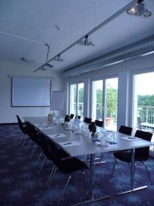 a large meeting room with a long table and chairs at Mein SchlossHotel in Heusenstamm