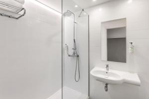 a white bathroom with a sink and a shower at B&B HOTEL Albacete in Albacete