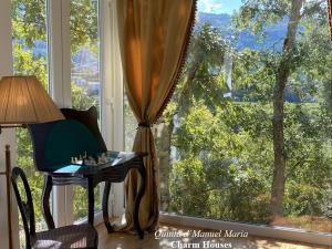 Zimmer mit einem Tisch und einem großen Fenster in der Unterkunft Quinta D`Manuel Maria- Rural Charm Houses in Amarante
