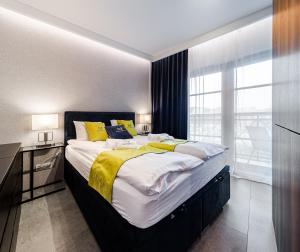 una camera da letto con un grande letto con cuscini gialli e bianchi di Apartamenty Gdansk EU - Dwie Motławy - OLD TOWN a Danzica