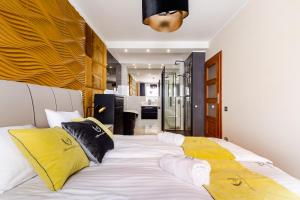 sypialnia z dużym białym łóżkiem z żółtymi poduszkami w obiekcie Apartamenty Gdansk EU - Apartament Panorama w Gdańsku