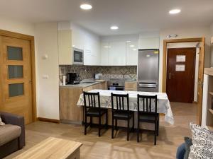 a kitchen with a table and chairs in a room at La Encina Azul Rooms-Grupo Rosa Azul in Ponferrada