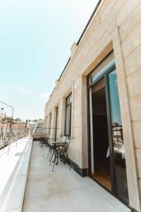 a balcony with chairs and tables on the side of a building at Hotel Verdzi in Kutaisi