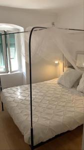 1 dormitorio con 1 cama blanca con dosel en Romantic gemstone in Pigna, en Pigna