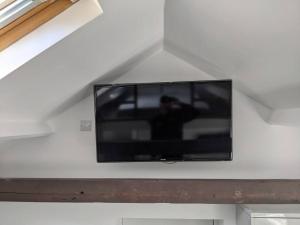 a flat screen tv hanging on a white wall at Orchard House in Peterborough