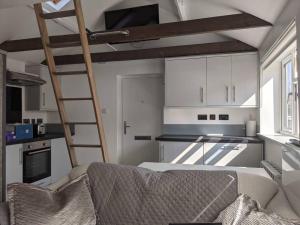 a living room with a loft bed in a kitchen at Orchard House in Peterborough