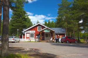un pequeño edificio con coches estacionados frente a él en Tapion Tupa, en Kalajoki