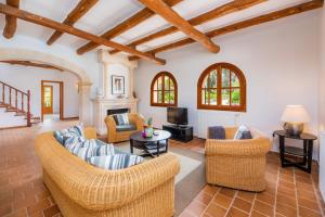 ein Wohnzimmer mit Korbmöbeln und einem Kamin in der Unterkunft Luxusfinca Son Mas in Felanitx