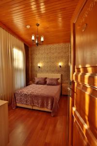a bedroom with a bed and a wooden ceiling at Mimoza Butik Otel Buyukada in Buyukada