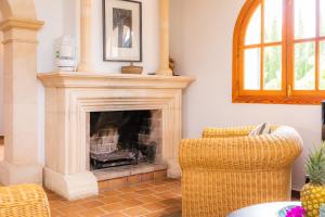 ein Wohnzimmer mit Kamin und Sessel in der Unterkunft Luxusfinca Son Mas in Felanitx