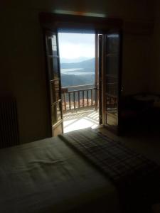 Schlafzimmer mit einer Tür, die auf einen Balkon führt in der Unterkunft Panoramic view in Delphi