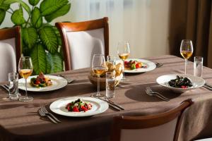 a table with plates of food and glasses of wine at Oak Leaf Residences in Budva