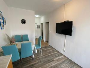 a living room with blue chairs and a flat screen tv at Apartmani Juricev Vodice in Vodice