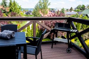a table and chairs on a deck with a grill at Kalinowe Wzgórza in Charzykowy