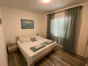 a bedroom with a bed with two towels on it at Apartmani Juricev Vodice in Vodice