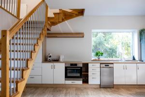 a kitchen with white cabinets and a staircase at Kalinowe Wzgórza in Charzykowy
