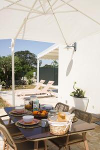 a table with food on it under an umbrella at EnjoyTrulli - Countryside in Noci