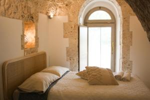 a bedroom with a bed with a window at EnjoyTrulli - Countryside in Noci