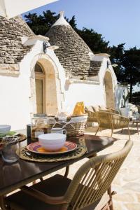 a table with a bowl and chairs on a patio at EnjoyTrulli - Countryside in Noci