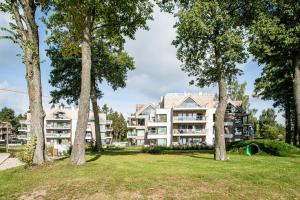 an apartment building with trees in front of it at Good Morning Sunshine - Nautica Resort Apartment in Giżycko