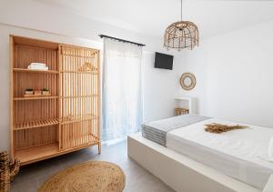 a bedroom with a bed and a book shelf at Aigaion Aetherium Apartments in Livadakia
