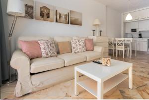 uma sala de estar com um sofá e uma mesa em Romana playa 724 em Marbella