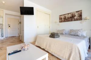 um quarto branco com duas camas e uma mesa em Romana playa 724 em Marbella