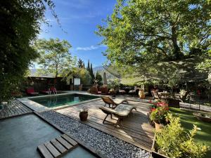 un patio trasero con terraza de madera y piscina en Fundalucia, en Quéntar