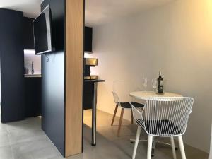 jadalnia ze stołem i krzesłami oraz telewizorem w obiekcie Acogedor Estudio suite en urbanización tranquila w mieście Famara
