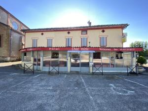 an empty parking lot in front of a building at Hôtel restaurant l'escale chez mimi in Bioule