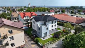 an overhead view of a white house with red roofs at NORD HOUSE Apartamenty in Władysławowo