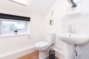 a white bathroom with a toilet and a sink at DD Apartment 10 - Free Parking - Fast WiFi in Castle Donington