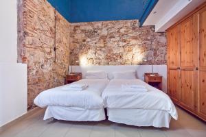 a bedroom with two beds and a brick wall at Inside Barcelona Apartments Sants in Barcelona