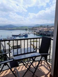 a chair sitting on a balcony with a view of a harbor at La Casa de la Bahía in San Vicente de la Barquera