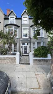 ein großes Haus mit einer Einfahrt davor in der Unterkunft Mulberry House in Llandudno