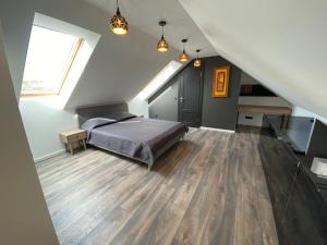 a attic bedroom with a bed and a staircase at Liepų apartamentai in Klaipėda