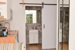 une cuisine avec des placards blancs et une porte coulissante dans l'établissement Apartament przy deptaku i Parku Zdrojowym - Polanica Zdrój, à Polanica-Zdrój 15 autres photos