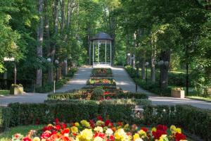 - un jardin avec un kiosque et des fleurs dans l'établissement Apartament przy deptaku i Parku Zdrojowym - Polanica Zdrój, à Polanica-Zdrój