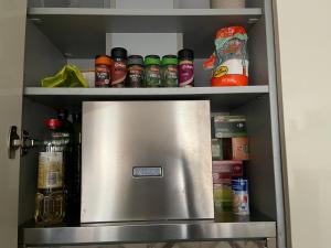 a refrigerator in a kitchen with spices and condiments at La Encina Azul Rooms in Ponferrada