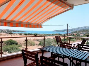 een tafel en stoelen op een balkon met uitzicht op de oceaan bij Sandra's Sea View at Sounio in Sounio