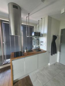 uma cozinha com armários brancos e um lavatório em By the Roof Apartments em Cracóvia
