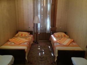 2 camas individuales en una habitación con lámpara en Guest House Deda Lali, en Kutaisi