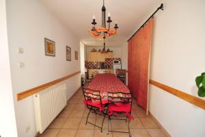 uma sala de jantar com uma mesa vermelha e cadeiras em La Rialhe em Taulignan