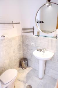 a bathroom with a toilet and a sink and a mirror at Sleepin Sevilla in Seville +32 photos