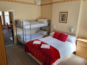 a bedroom with a bed and two bunk beds at Cleveland Court Apartments in Blackpool