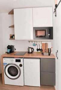 a kitchen with a washing machine and a microwave at Apartament przy deptaku i Parku Zdrojowym - Polanica Zdrój in Polanica-Zdrój