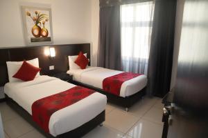 a hotel room with two beds with red pillows at Easy Inn Hotel Suites in Amman