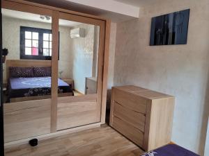 1 dormitorio con una puerta de cristal que conduce a una cama en Villa RENE, en Saint-Génis