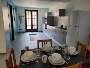 una cocina con una mesa con platos y vasos. en Villa RENE, en Saint-Génis
