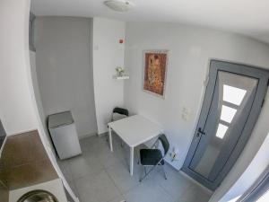 ein kleines weißes Zimmer mit einem Tisch und einem Fenster in der Unterkunft Piraeus Urban Paradise L in Piräus